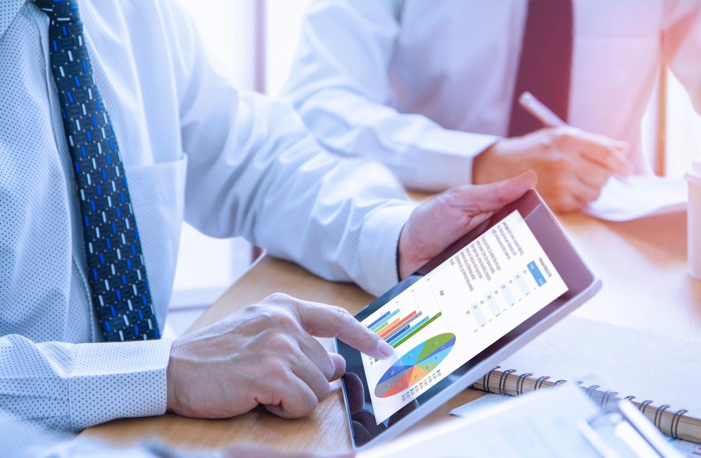 man holding ipad with charts on screen