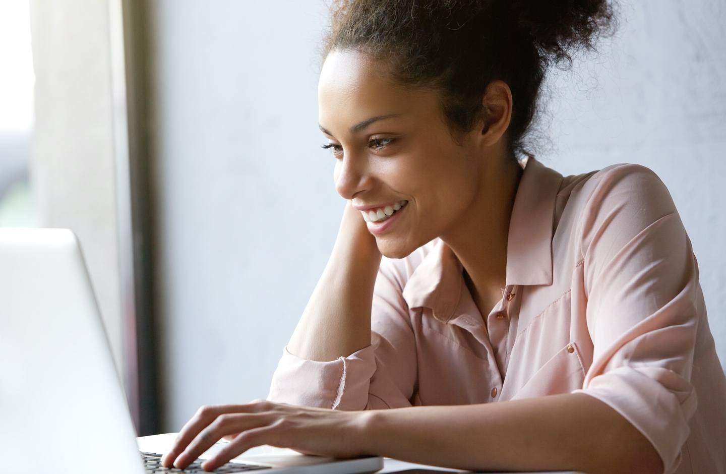 young woman smiling while looking at computer