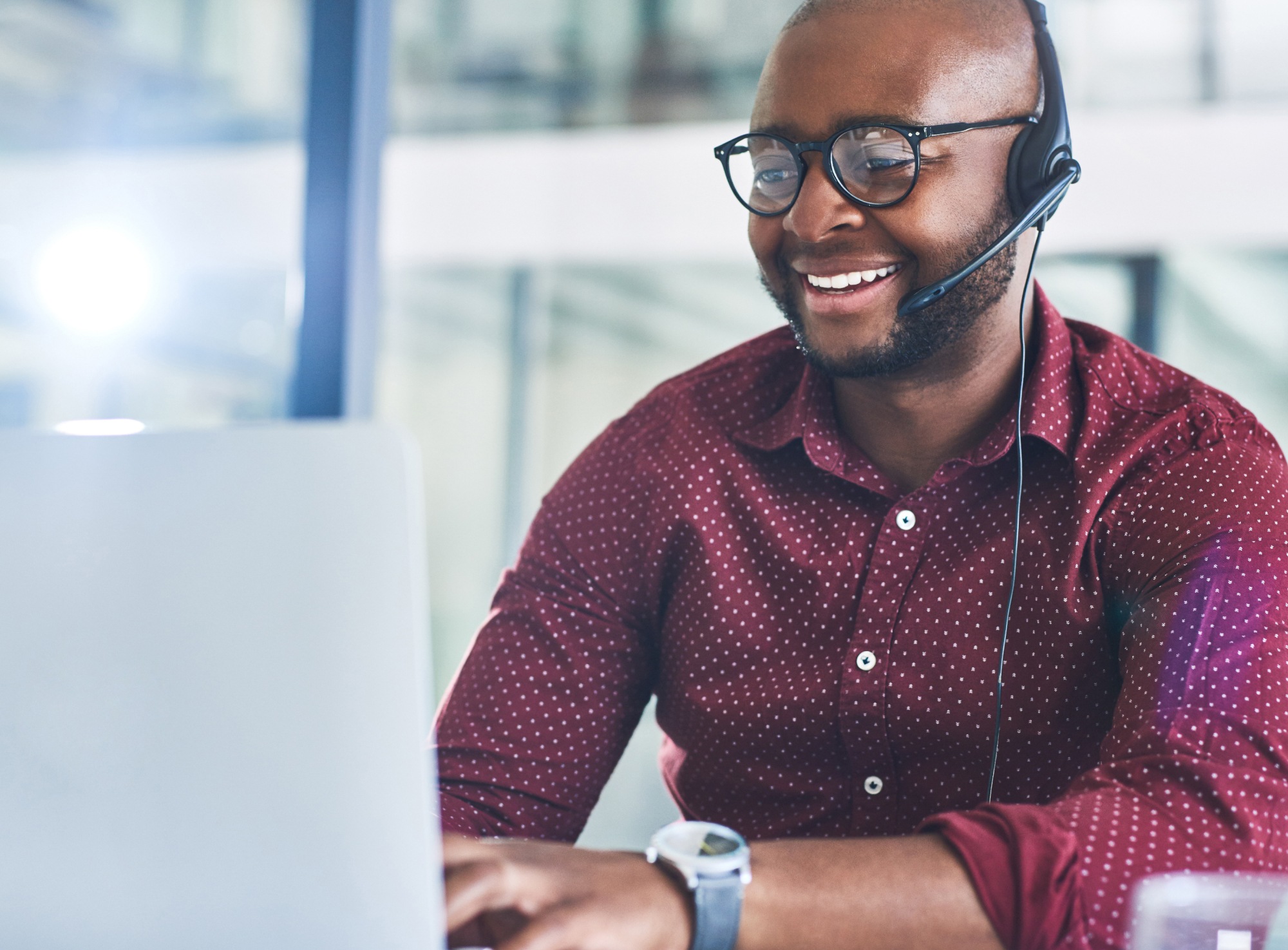 man working on laptop while on phone